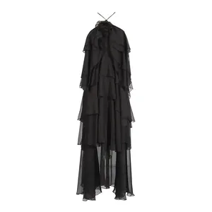 Macro view of an elegant black tiered ruffled maxi dress featuring halter neck and flower