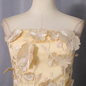Close-up detail of champagne strapless top featuring elegant 3D floral embroidery