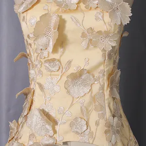 Detail shot of sleeveless top with 3D floral embroidery and elegant satin finish.