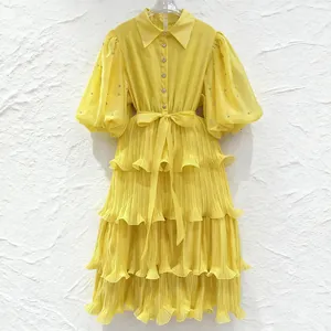 Detail view of yellow French style tiered midi dress with puff sleeves and ruffles