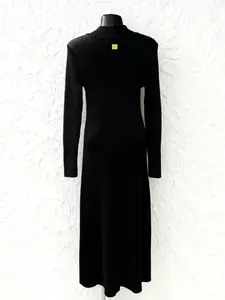 Vista posteriore di un elegante abito lungo in maglia a coste nero con logo oro