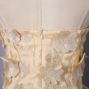 Close-up of champagne strapless top with 3D floral embroidery and back zipper detail