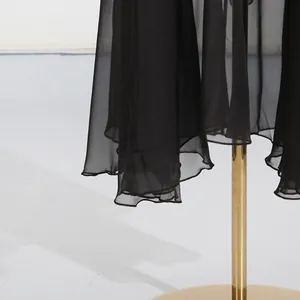 Detail of the ruffled hem on an elegant black long dress made of lightweight chiffon.