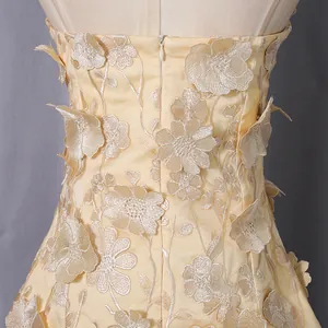 Detailed back view of strapless top featuring delicate 3D floral appliqués and hidden zipper
