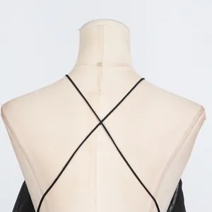 Detail view of the elegant halter backless dress with black cross straps on mannequin.