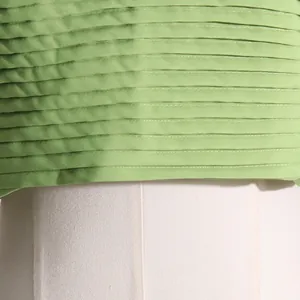 Primer plano detallado de los finos pliegues horizontales en tela verde claro