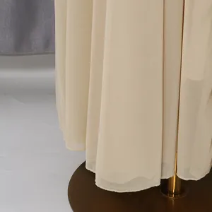 Detailed macro shot of elegant pleated beige mesh long dress hem showing fine fabric texture
