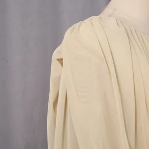 Close-up of pleated chiffon fabric on an elegant cream French-style evening gown.