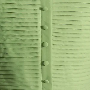 Primer plano de la textura de tela plisada verde claro con botones forrados