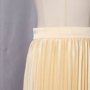Detailed view of high-waist champagne pleated skirt showing elegant satin texture