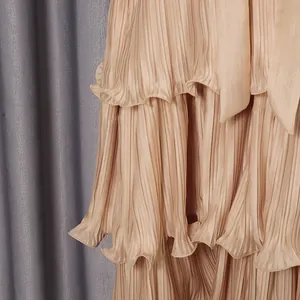 Close-up detail of champagne pleated tiered layers on a French style elegant maxi dress