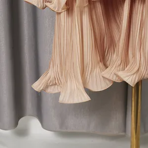Macro detail of elegant apricot pleated dress hem featuring a delicate wavy edge design