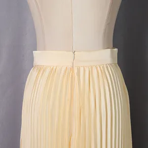 Close-up detail of high-waist cream pleated skirt featuring a back invisible zipper