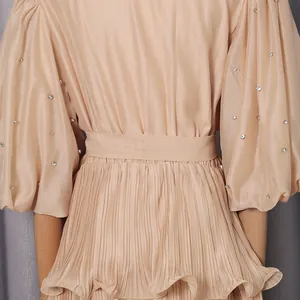 Detail of French bubble sleeve dress with pleated texture and rhinestone studs.