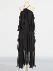 Elegant black tiered ruffle maxi dress with halter neck and backless design on mannequin