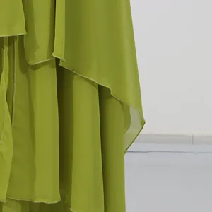 Close-up detail showing the layered asymmetrical hem of this light green chiffon vacation dress