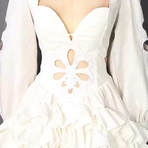 Detail van witte Franse jurk met bloemige uitsparingen en een gelaagde rok met ruches