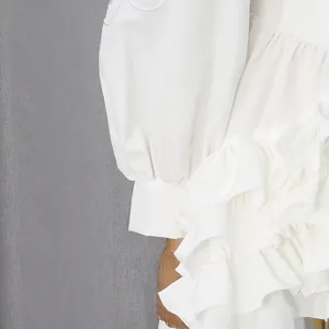 Detailopname van een witte jurk in Franse stijl met gelaagde ruches en pofmouwen
