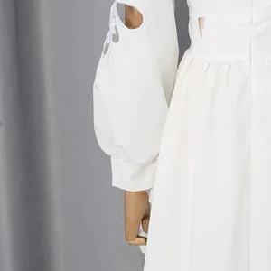 Detail van witte jurk in Franse paleisstijl met opengewerkt borduursel op de pofmouwen