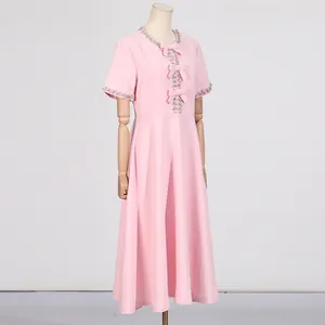 Detailansicht eines rosa süßen Kleides mit Strasskragen und Schleifenakzenten
