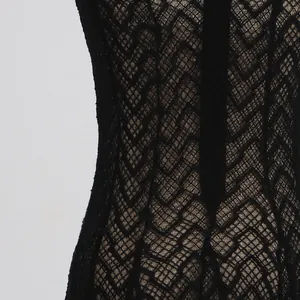 Macro view of the intricate black zigzag lace texture on an elegant maxi dress