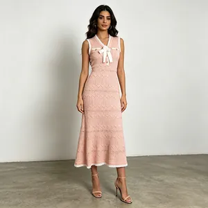 Detailed view of pink sleeveless knit fishtail dress with white lace trim and bow accent