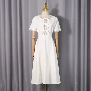 Elegant weißes Midikleid mit Strass-Ausschnitt und Schleifen-Details auf Schaufensterpuppe
