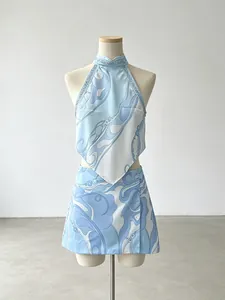 Blue and white abstract print two-piece vacation set with halter top and mini skirt.