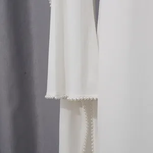 Close-up of elegant pearl bead trim on white long sleeve French style evening dress