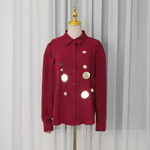Detalle de la camisa burdeos de manga larga con adornos de lentejuelas doradas brillantes