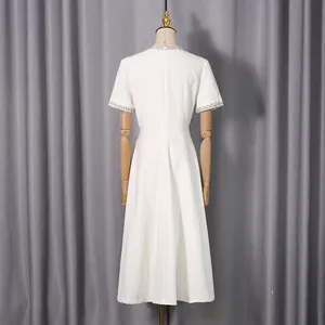 Rückansicht eines minimalistischen weißen Kurzarmkleids mit perlenbesetztem Ausschnitt.