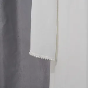 Elegant macro view showing luxurious pearl embellishments on a white French style dress cuff