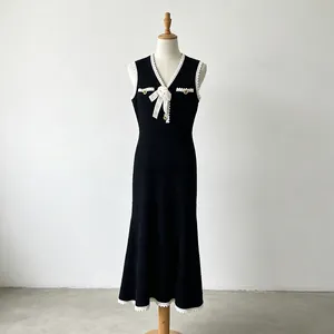 Sleeveless knitted fishtail dress with white lace trim and floral detail on mannequin