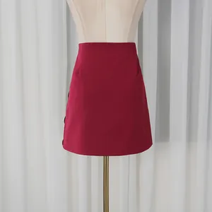 Vista detallada de la minifalda burdeos de cintura alta en un maniquí de costura