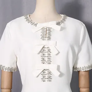 Nahaufnahme von elegantem strassbesetztem Ausschnitt und Schleifen an weißem Kleid