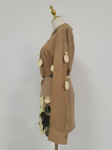 Detalle lateral de un conjunto de camisa marrón de manga larga y falda con brillo