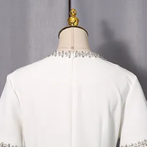 Nahaufnahme des weißen Kleid-Ausschnitts mit funkelnden Strasssteinen und Reißverschluss