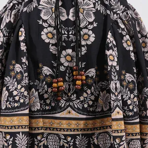 Close-up of vintage floral print fabric with wooden beads on black French retro dress detail