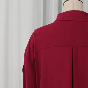 Detalle trasero de una elegante blusa granate de manga larga con cuello de camisa