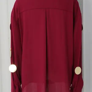 Detalle de blusa burdeos de manga larga con lentejuelas doradas y espalda plisada