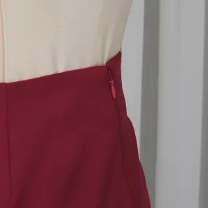 Detalle de la cremallera lateral oculta en una falda burdeos de talle alto para mujer