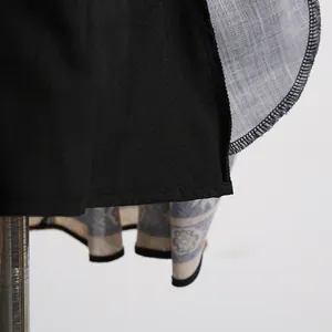 Close-up of fine stitching and vintage floral print lining on black sleeveless dress