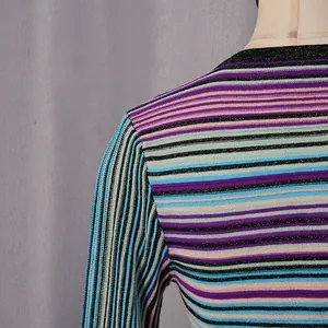 Close-up detail of a colorful striped knit dress showing the shoulder seam and texture.