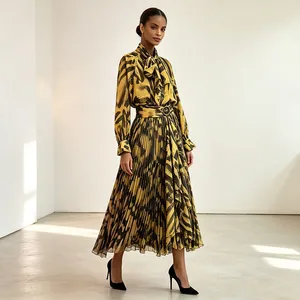Elegant two-piece set featuring long sleeve tie-neck top and pleated midi skirt with print.