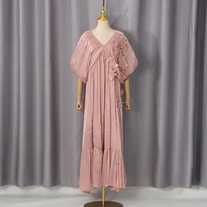 Vue détaillée d'une robe longue rose avec col en V et applications florales 3D élégantes