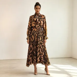 Detail showing the pleated maxi skirt and tie-neck top of an abstract print set