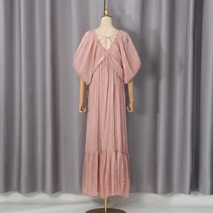 Vue détaillée de la robe longue rose chatoyante de style vacances avec manches chauve-souris.