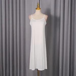 Full-length white slip dress with V-neck on a mannequin against a grey curtain backdrop