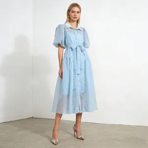 Vista completa de un vestido azul claro con mangas abullonadas, solapas y bordados finos.
