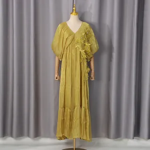 Détail d'une robe longue jaune à col en V ornée d'élégantes fleurs en relief 3D
